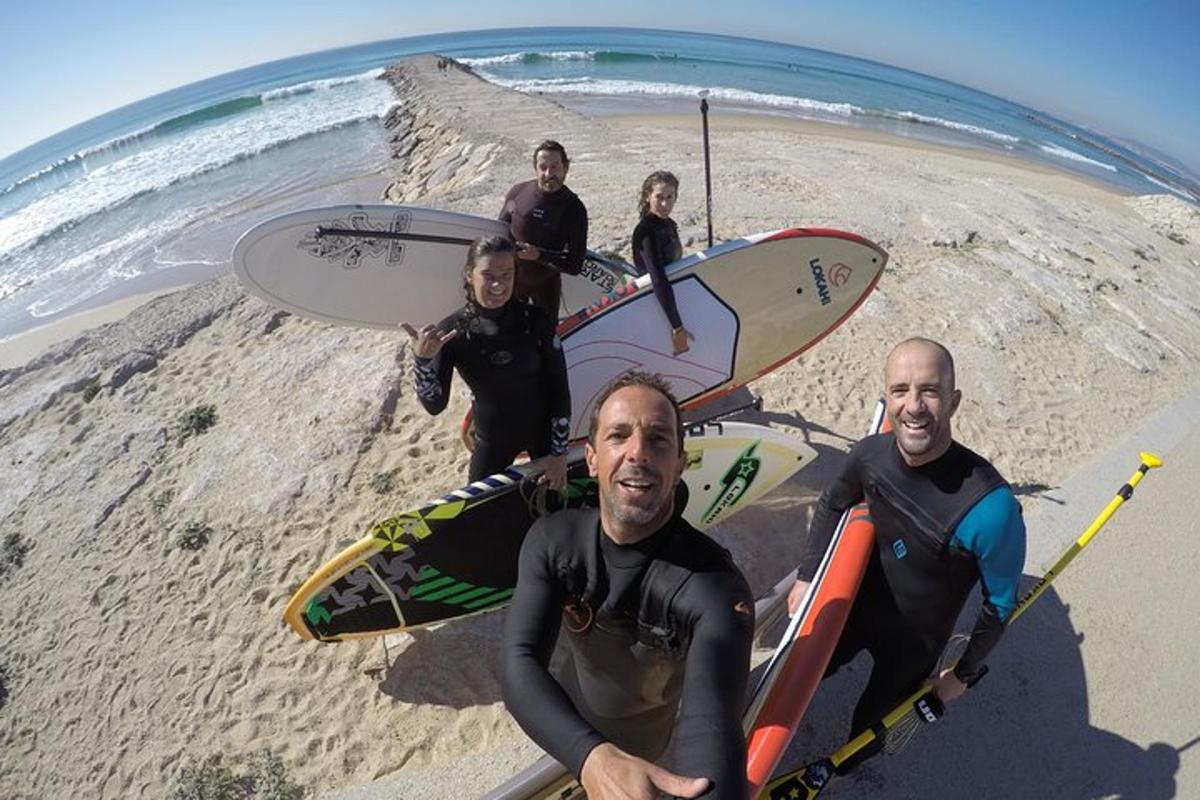 Un grupo de personas de pie en la playa con tablas de surf.
