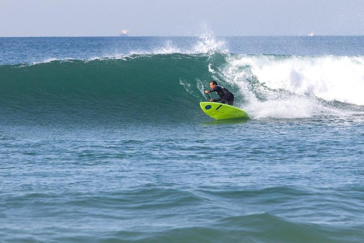 mężczyzna jadący na żółtej desce surfingowej na fali w oceanie