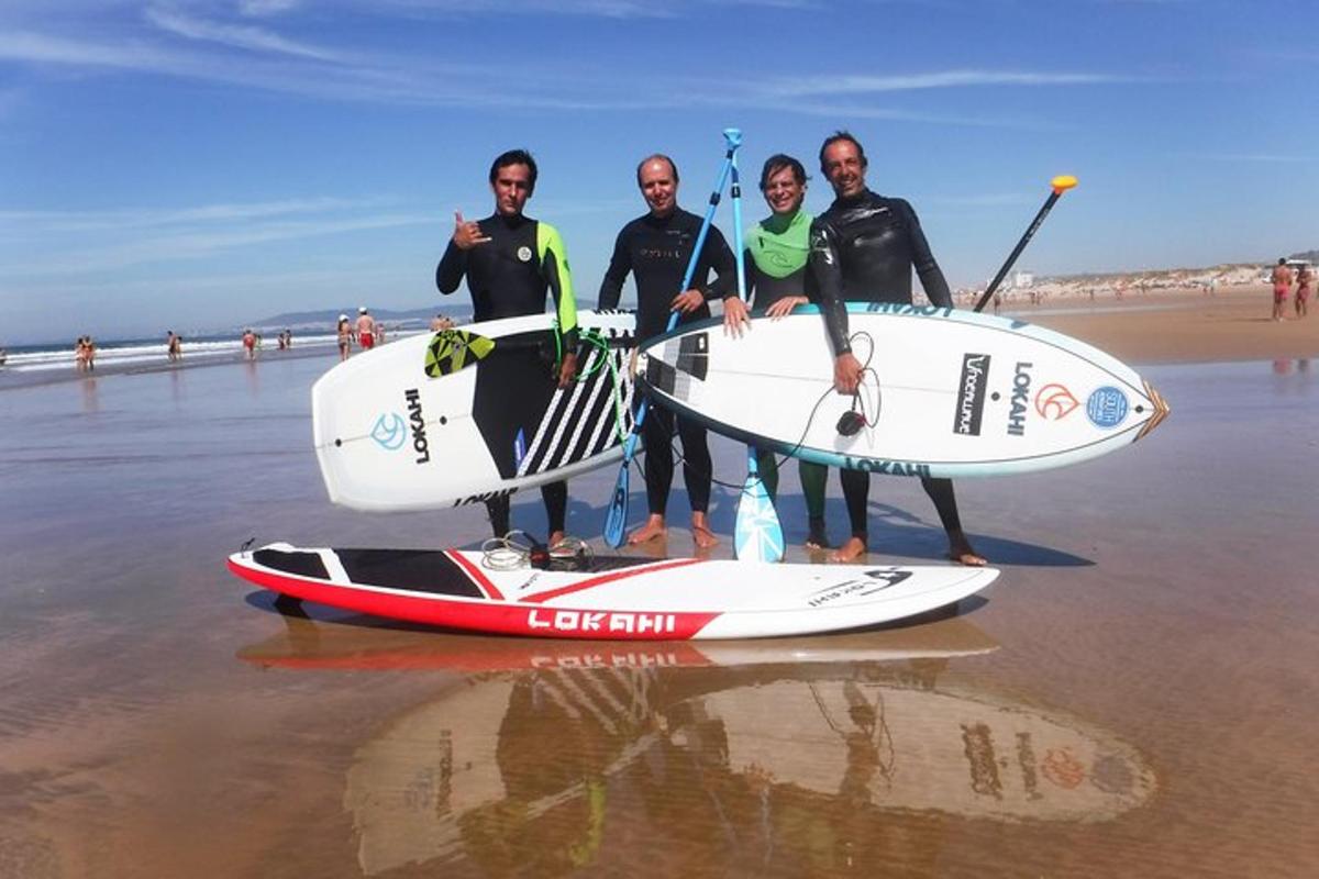Un grupo de personas de pie en la playa con sus tablas de surf.