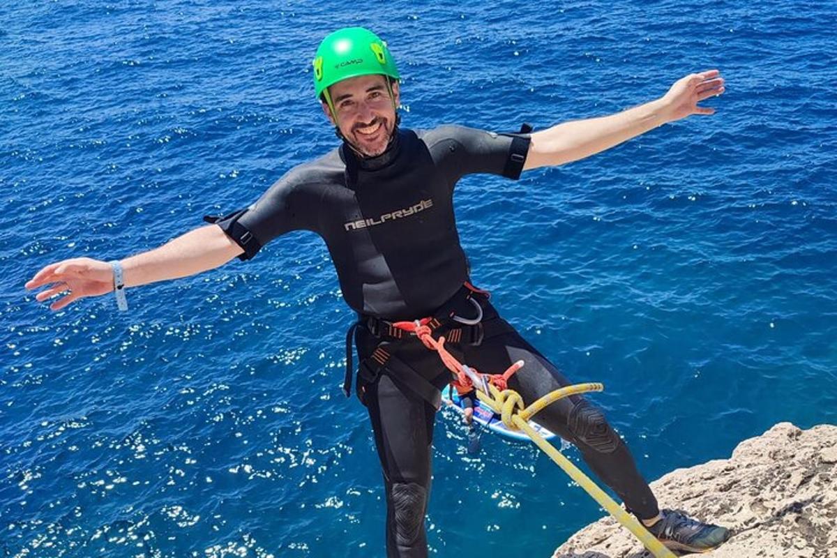 un uomo in piedi su una roccia nell'acqua