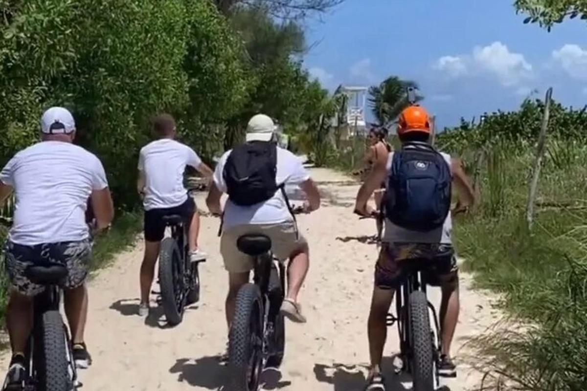 skupina lidí jedoucích na kolech po nezpevněné cestě