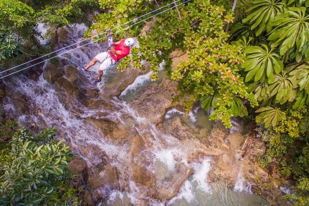 seorang lelaki berjalan di atas garis zip di atas air terjun
