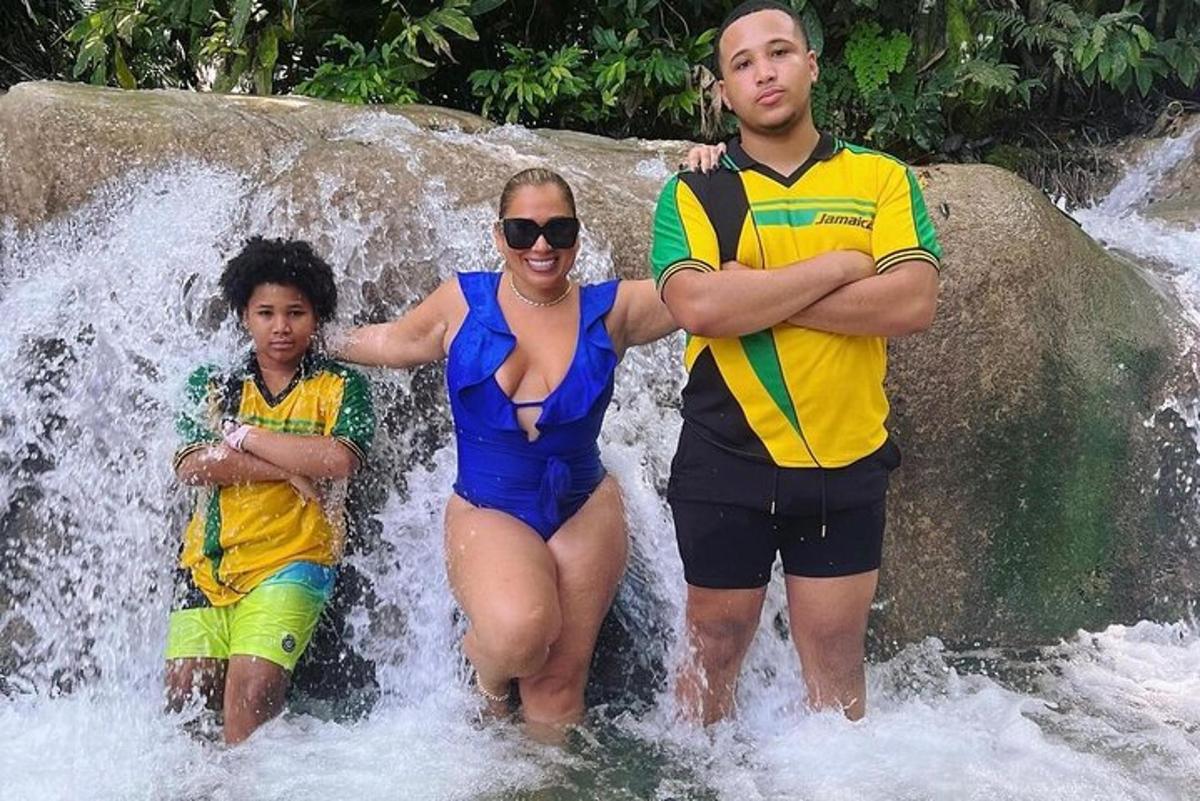Una mujer, un hombre y un niño de pie en una cascada