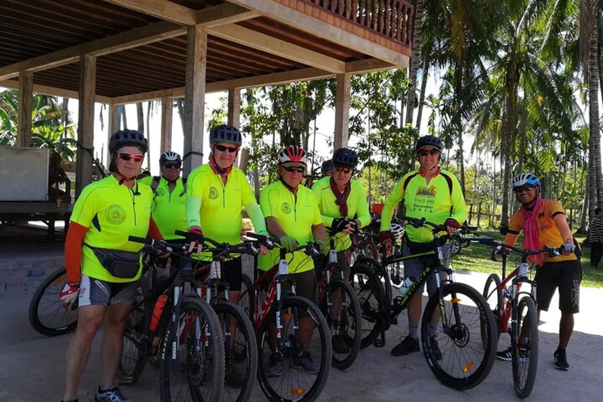 um grupo de pessoas com camisas amarelas posando com suas bicicletas