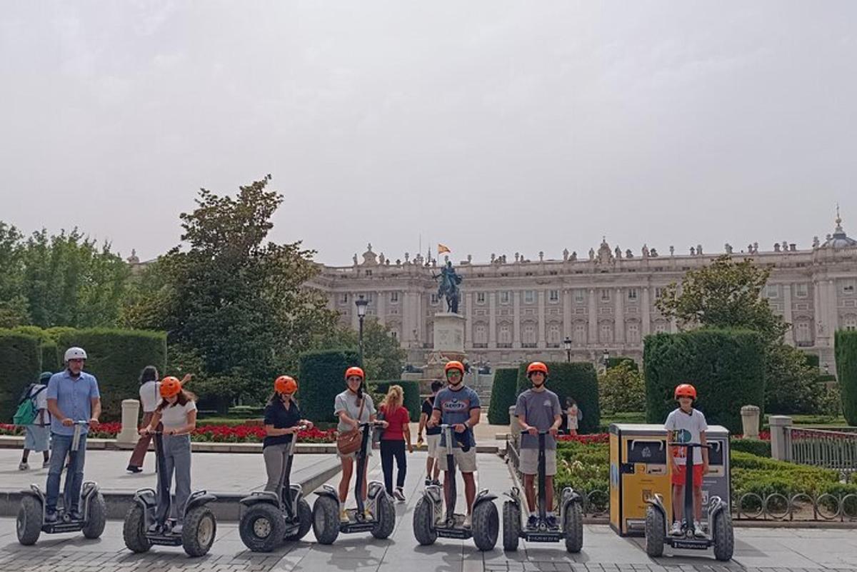 skupina lidí jedoucích na segwayích před budovou