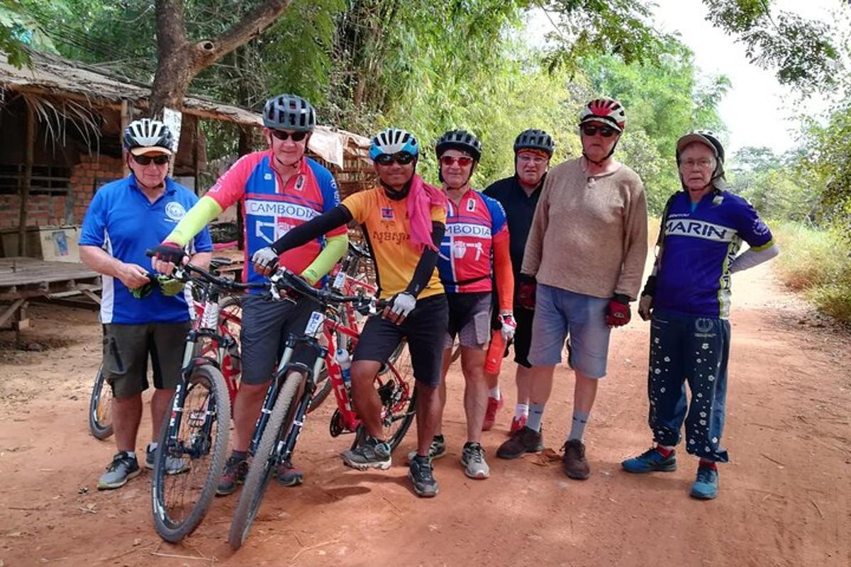 un gruppo di persone con le biciclette su una strada sterrata