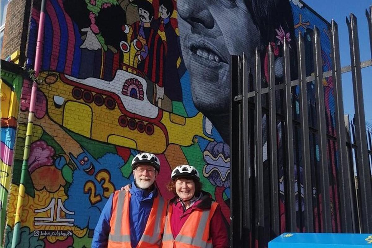 a man and woman standing in front of a mural
