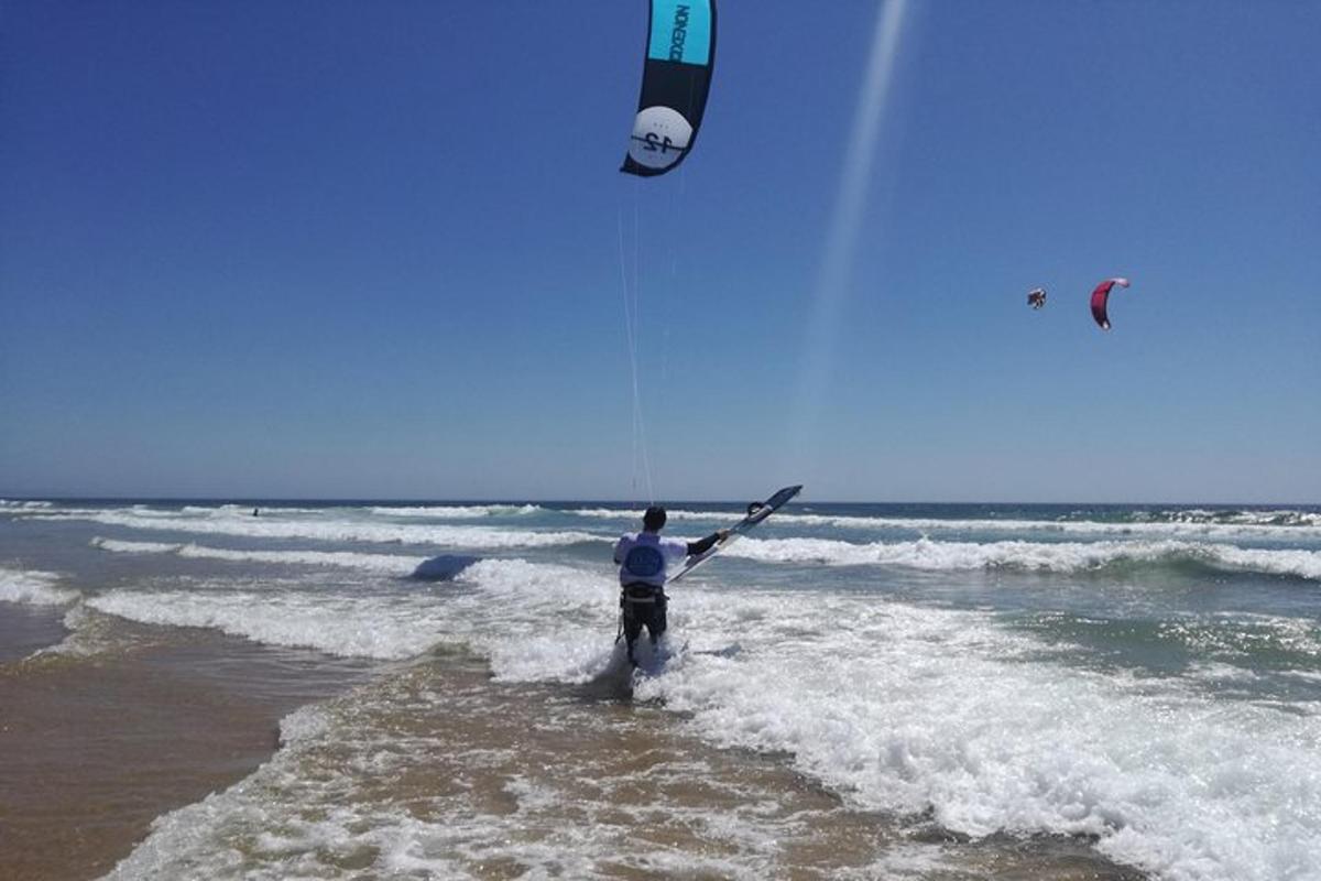 un uomo è in piedi nell'oceano con un aquilone