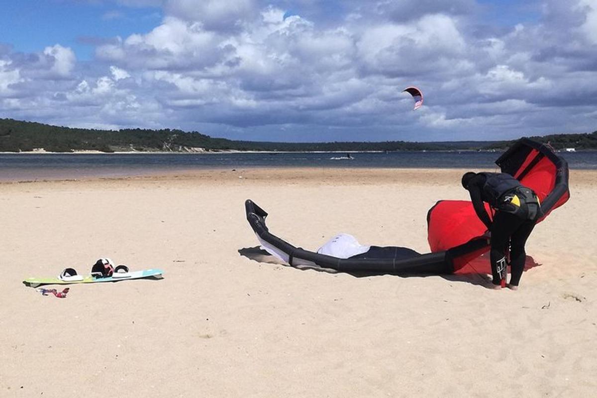 un uomo in piedi su una spiaggia con un aquilone sulla spiaggia