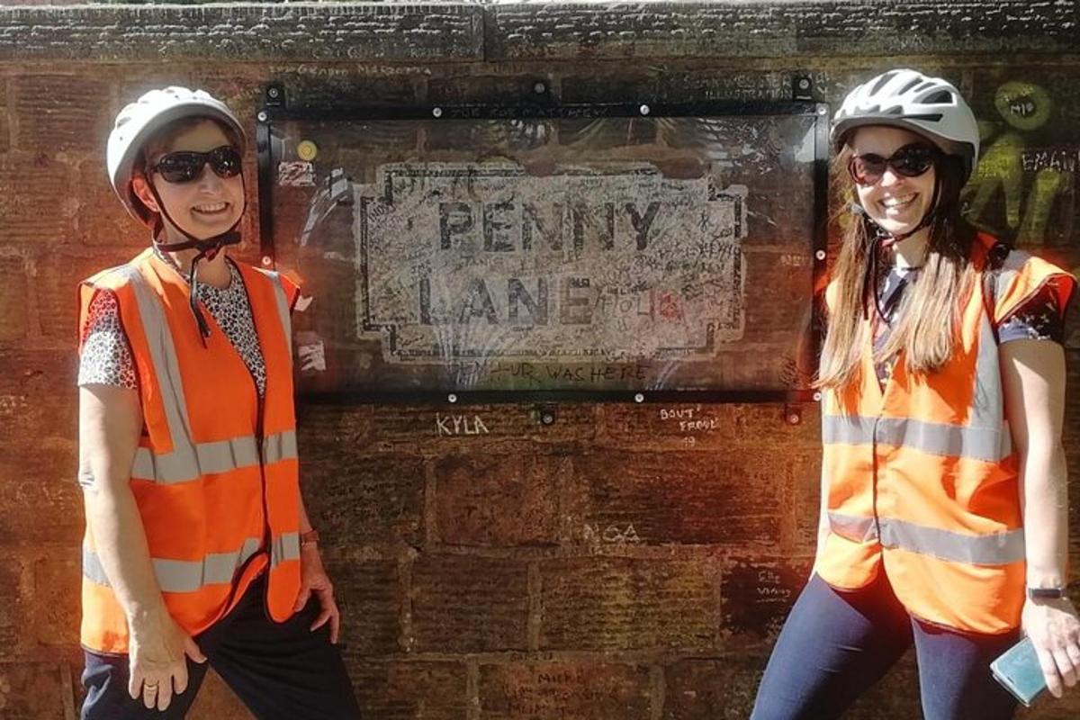 two women wearing safety vests standing next to a brick wall