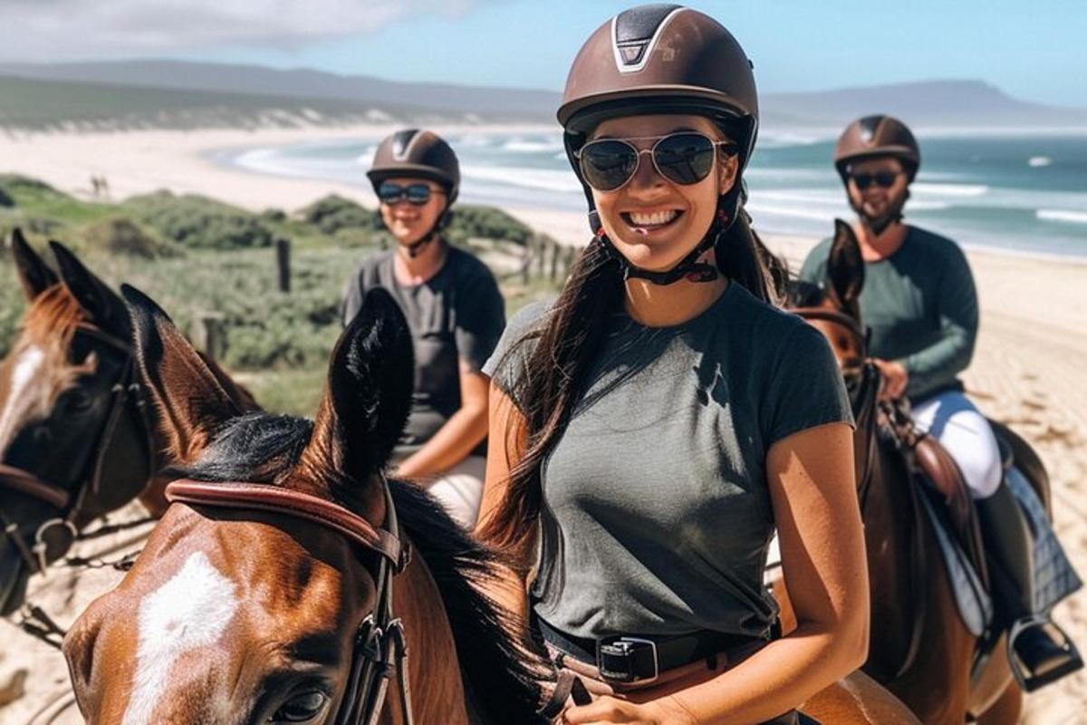 een groep mensen die op paarden op het strand rijden