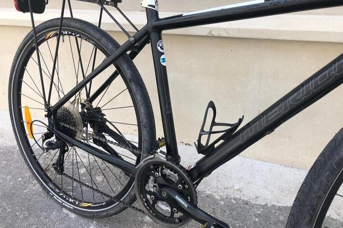 một chiếc xe đạp màu đen đỗ cạnh một tòa nhà