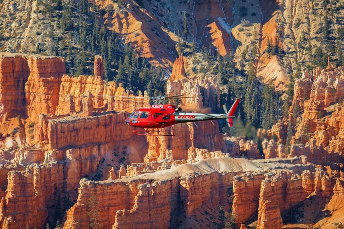 Ein roter Hubschrauber fliegt über den Grand Canyon
