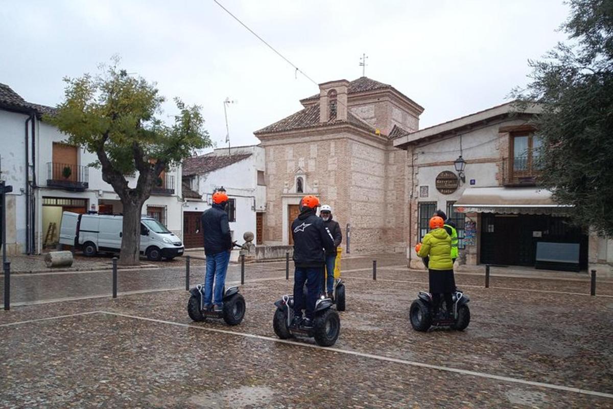 tři lidé jedoucí na segwayích před budovou