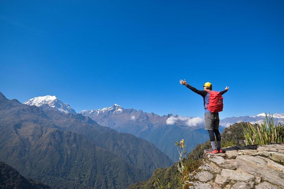 seorang pria berdiri di puncak gunung dengan kedua tangannya terentang
