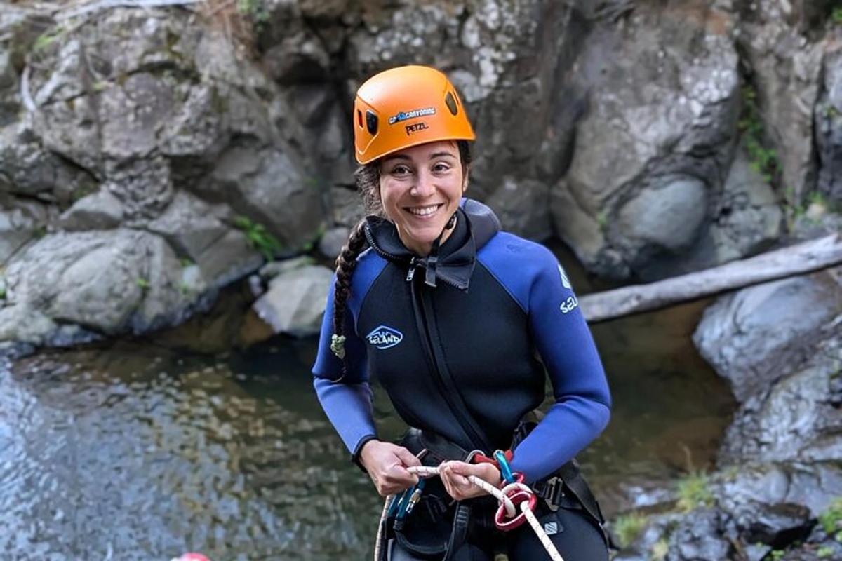 a woman wearing an orange helmet standing in the water