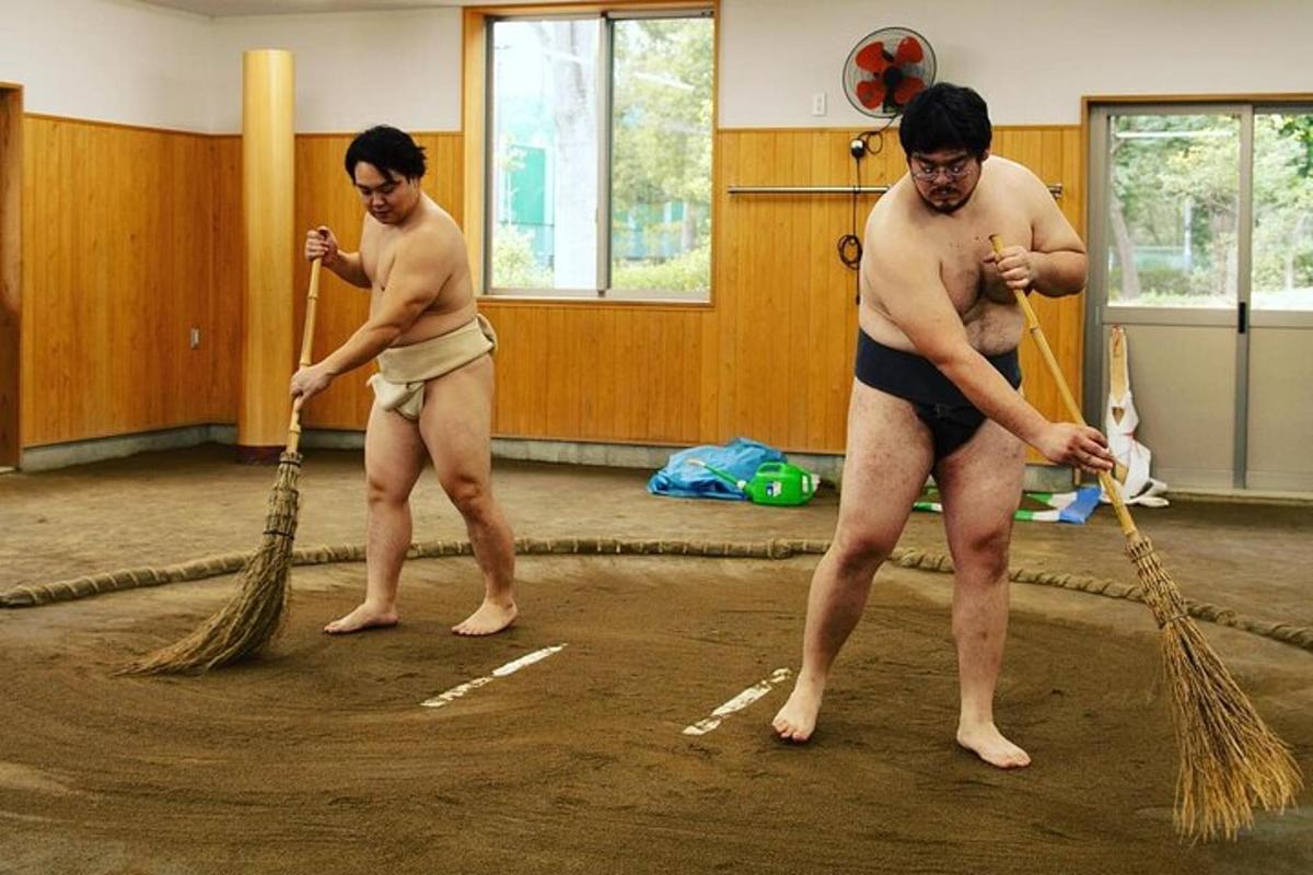 dois homens de maiô brincando com uma corda