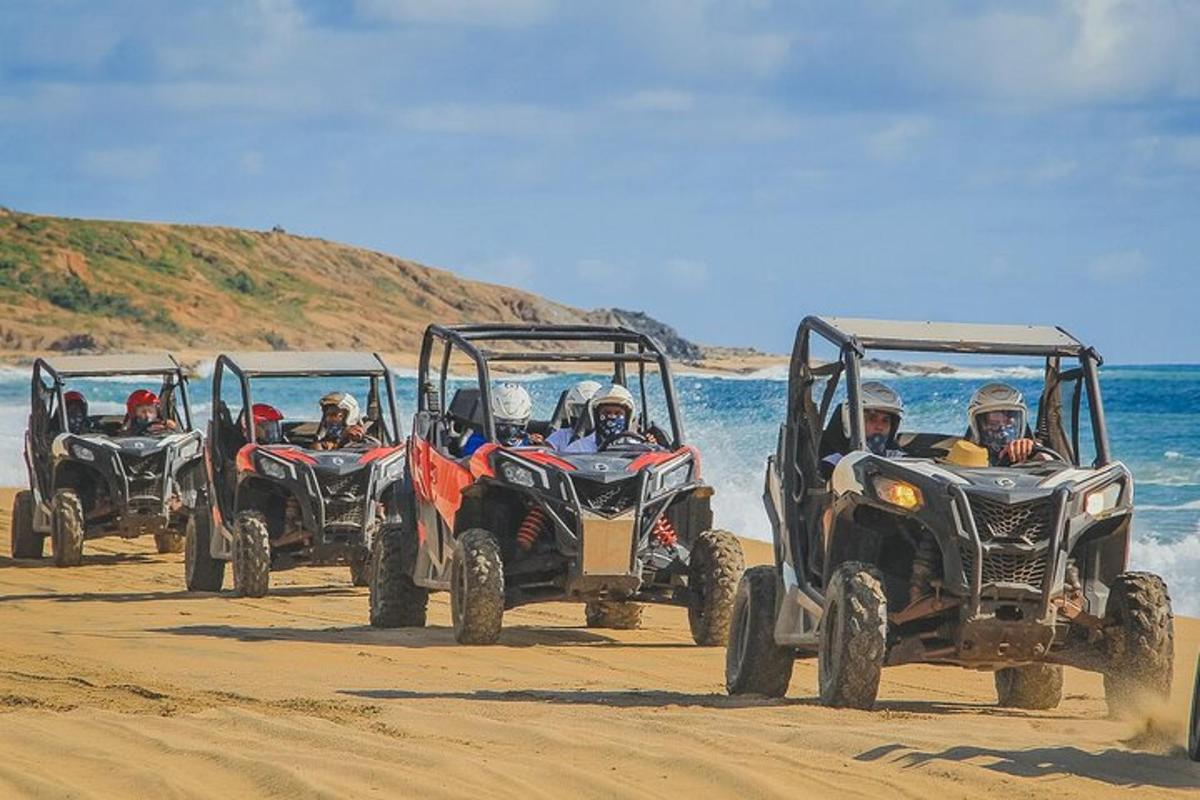 Un grupo de personas conduciendo vehículos todo terreno en la playa.