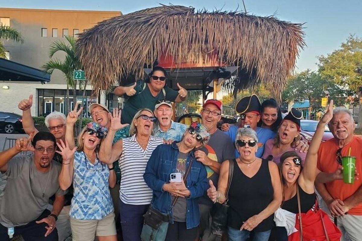 un gruppo di persone in posa per una foto davanti a una capanna di paglia
