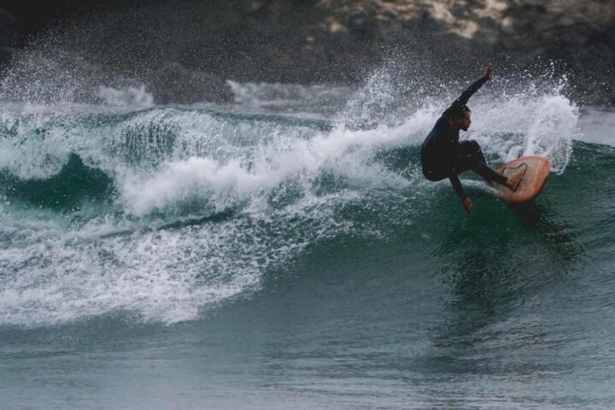 un uomo che cavalca un'onda su una tavola da surf nell'oceano