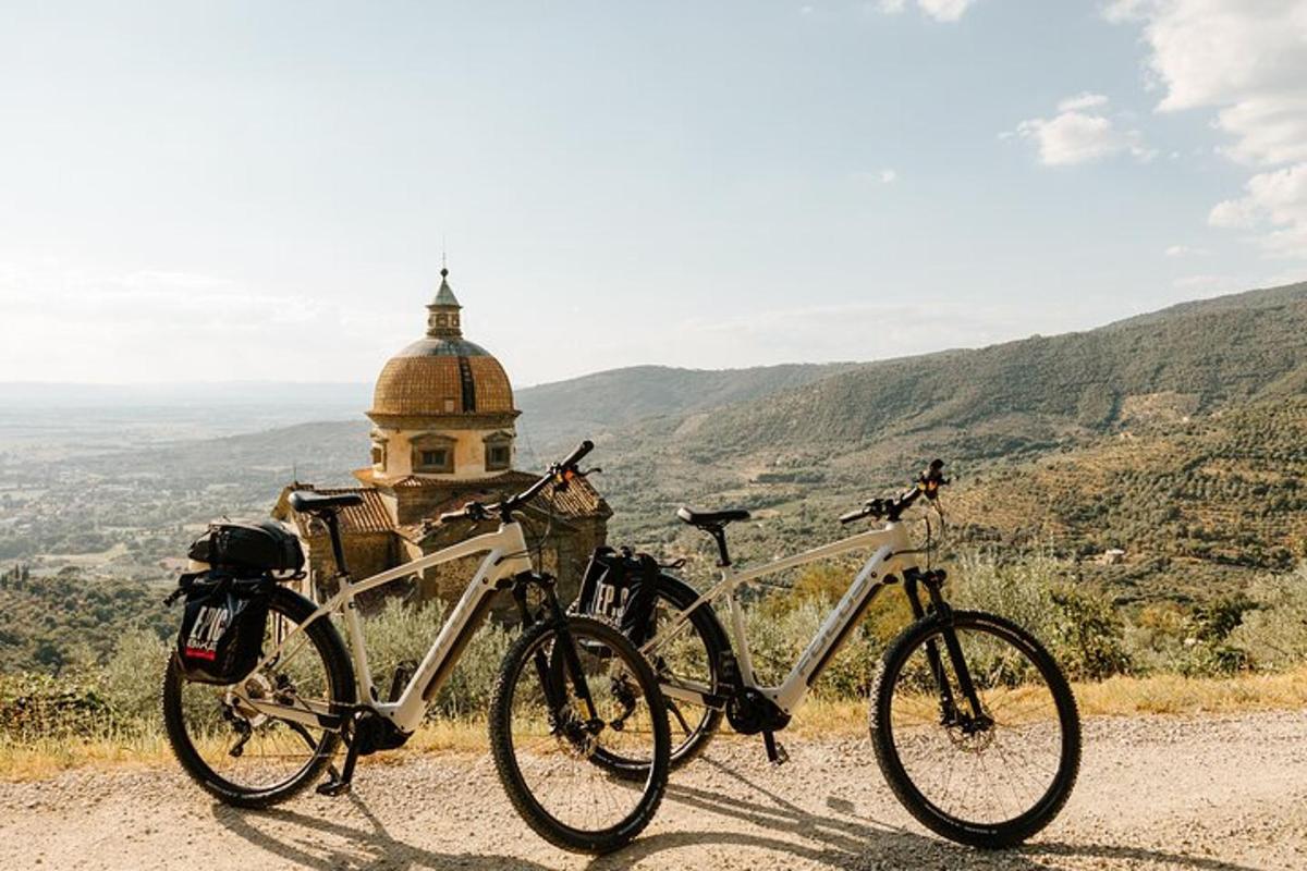 two bikes parked on a hill with a building in the background