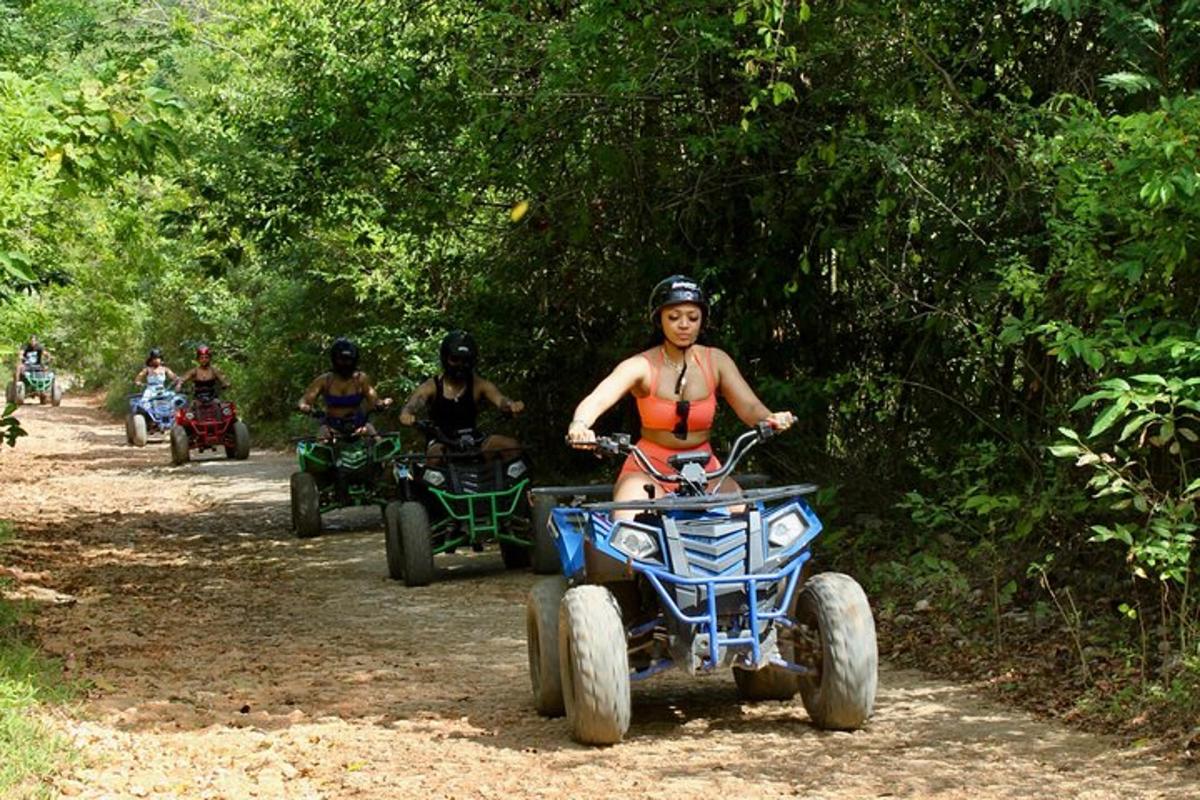 una dona en bikini muntant un quad per un sender