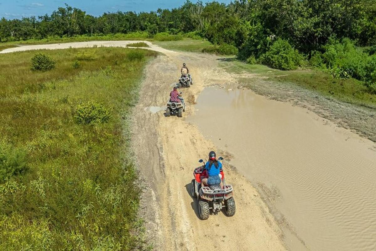 未舗装道路でATVに乗っている人々のグループ