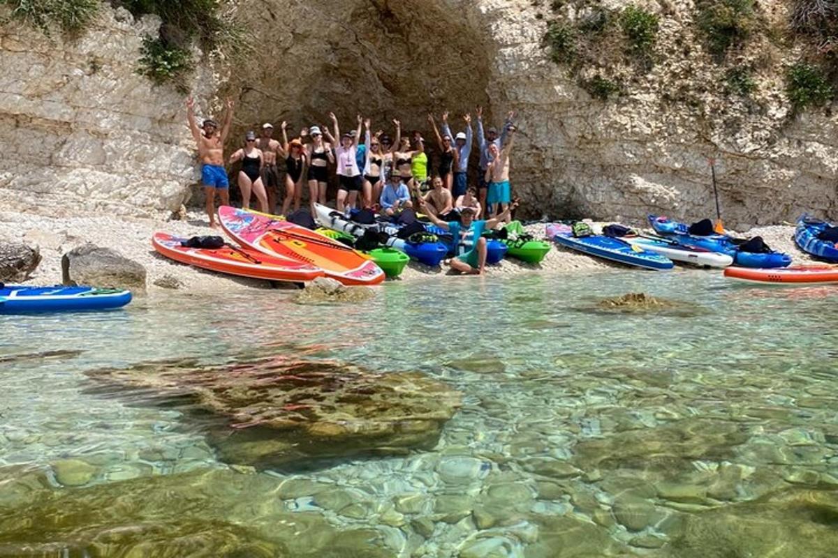 un grup de persones dempeus a l'aigua al costat de vaixells
