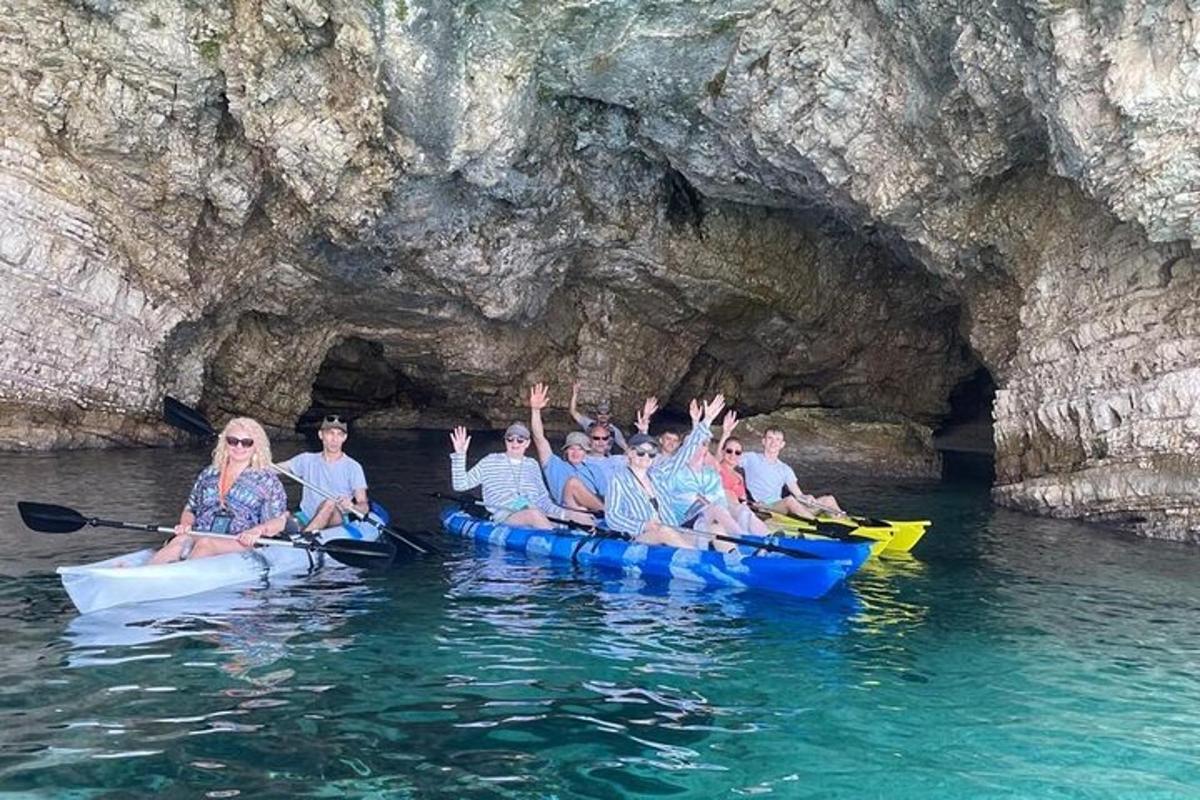một nhóm người chèo thuyền kayak trước một hang động