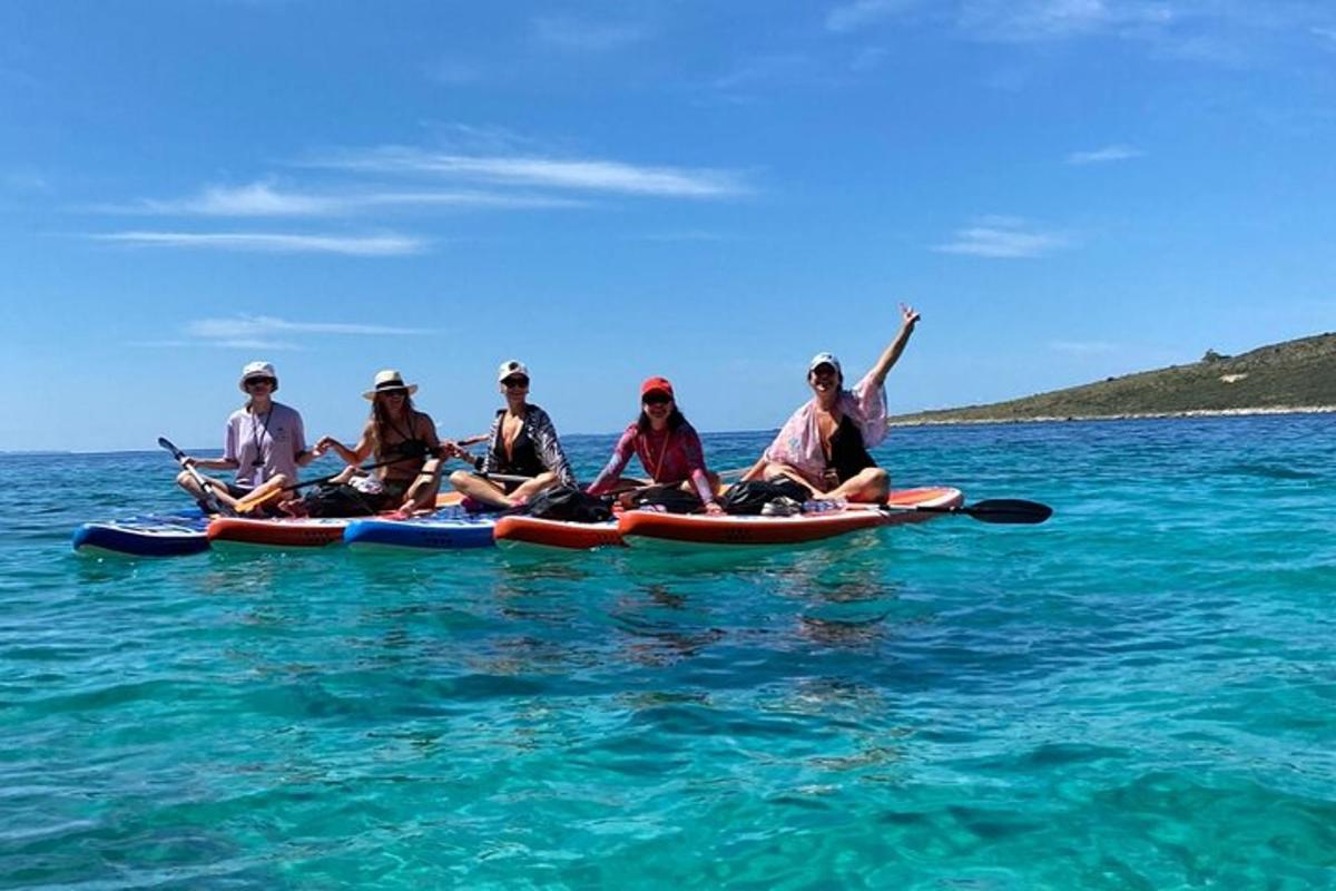un grup de persones assegudes en caiacs a l'aigua