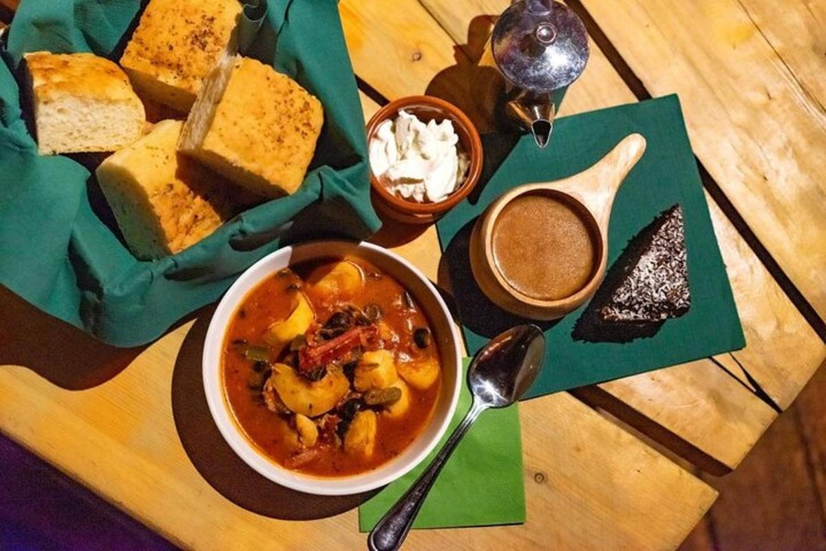 a table with a bowl of soup and a plate of bread