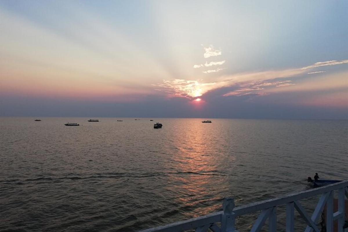um pôr do sol sobre o oceano com barcos na água