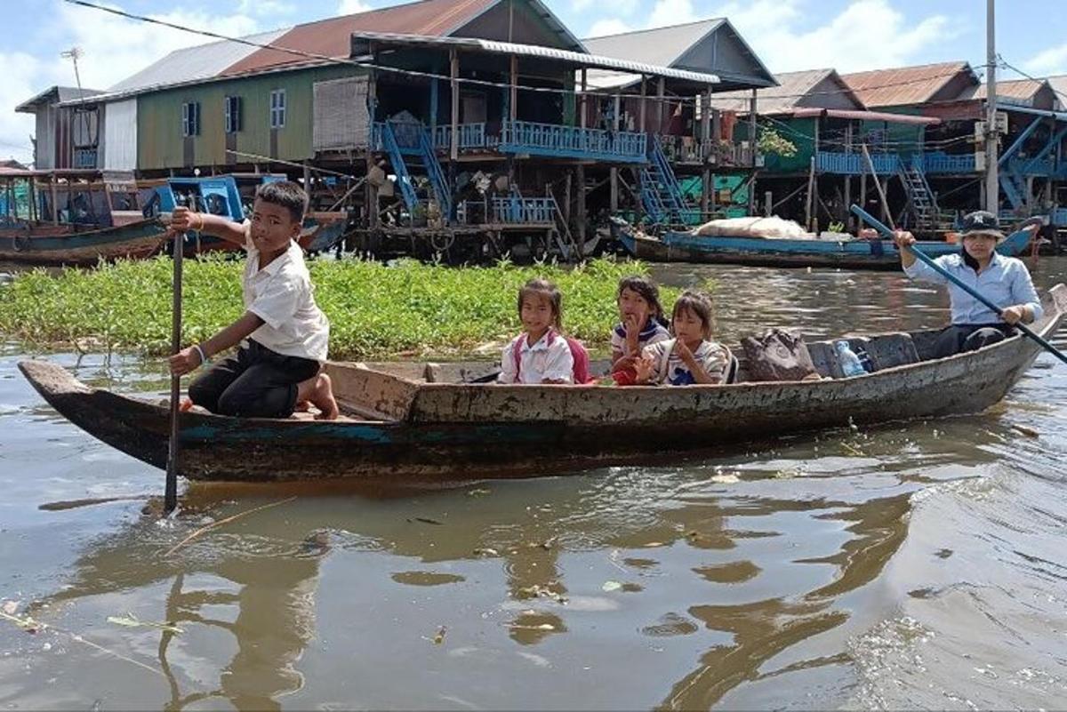 um grupo de crianças sentadas em um barco na água