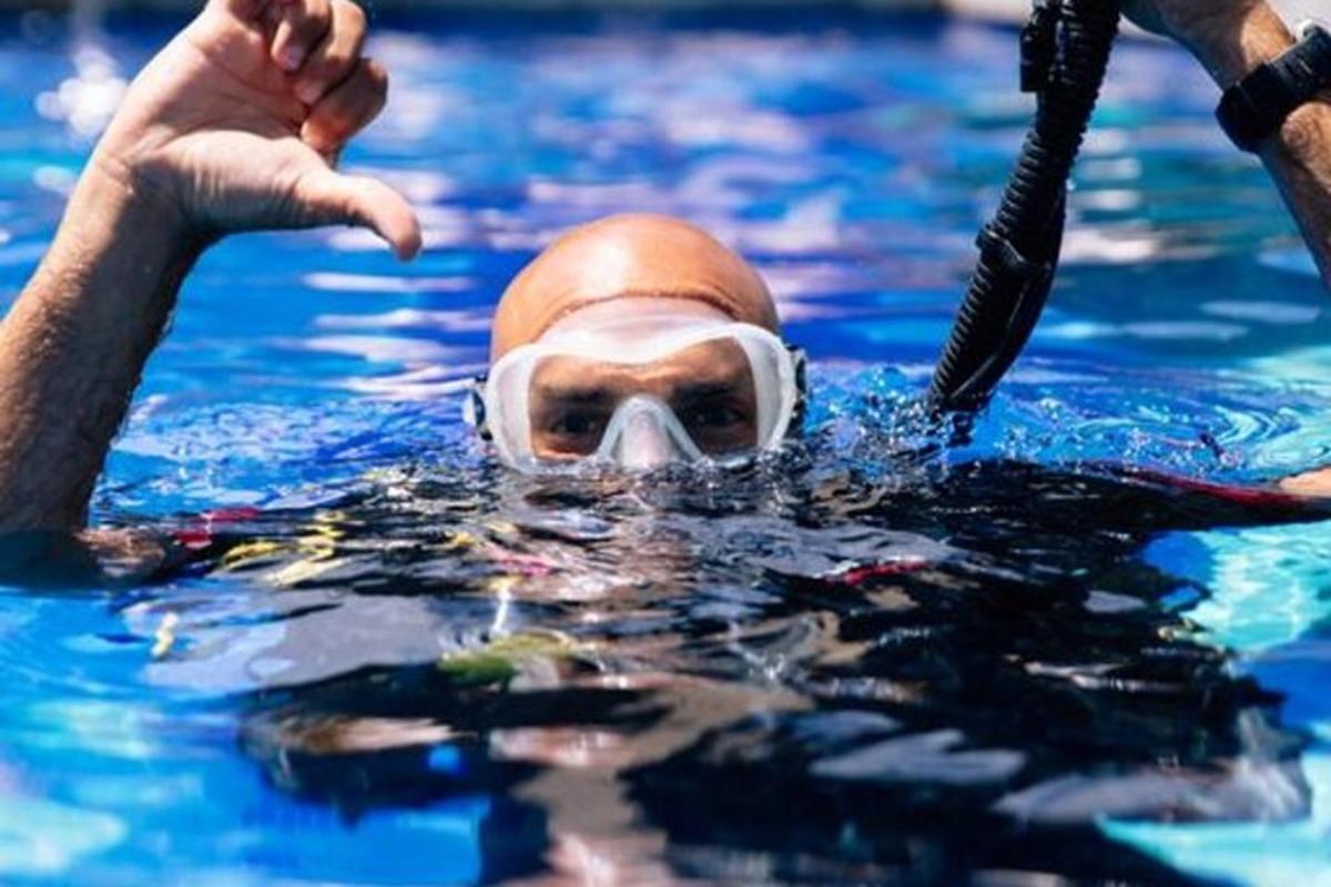 una persona in piscina che indossa una maschera