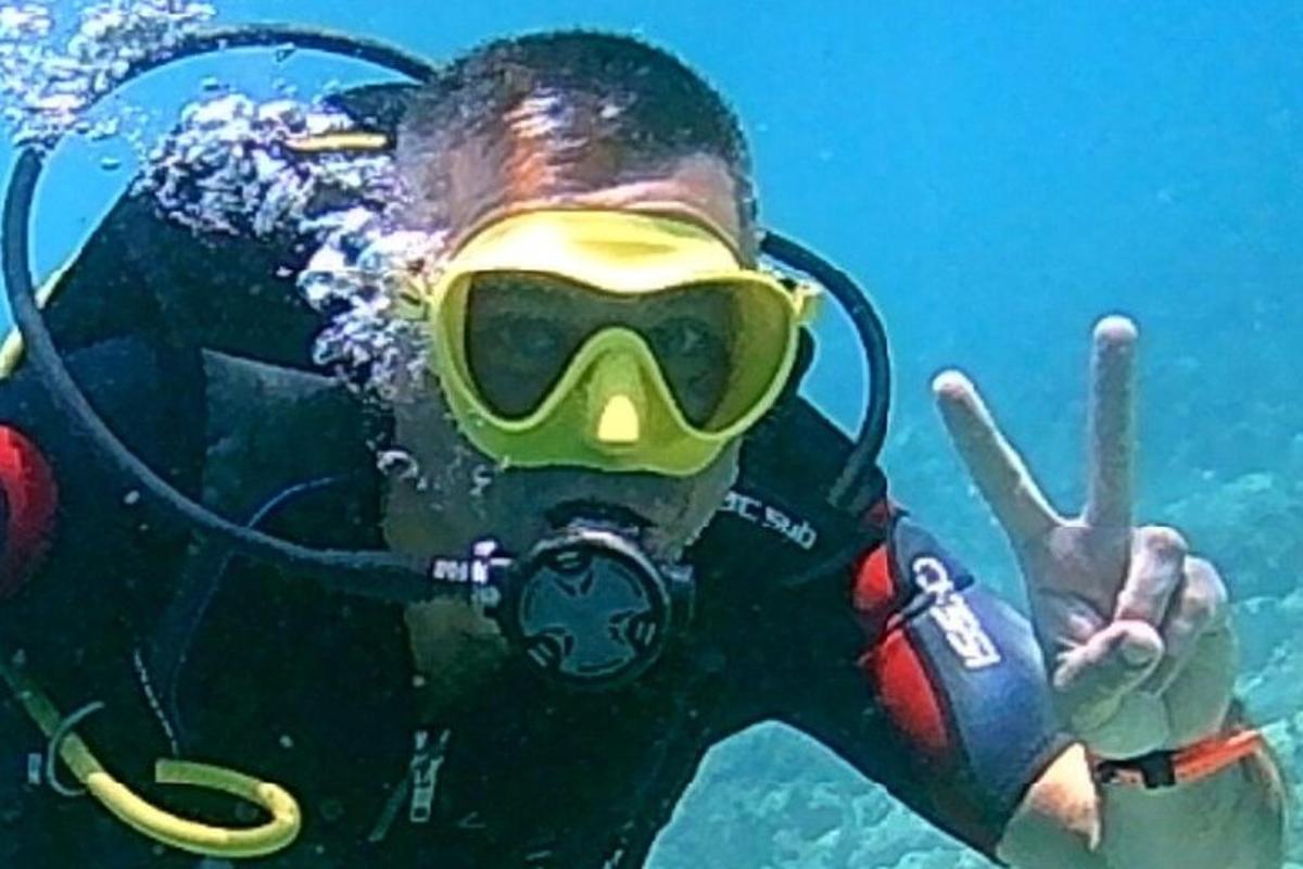 a man in a diving mask giving the peace sign