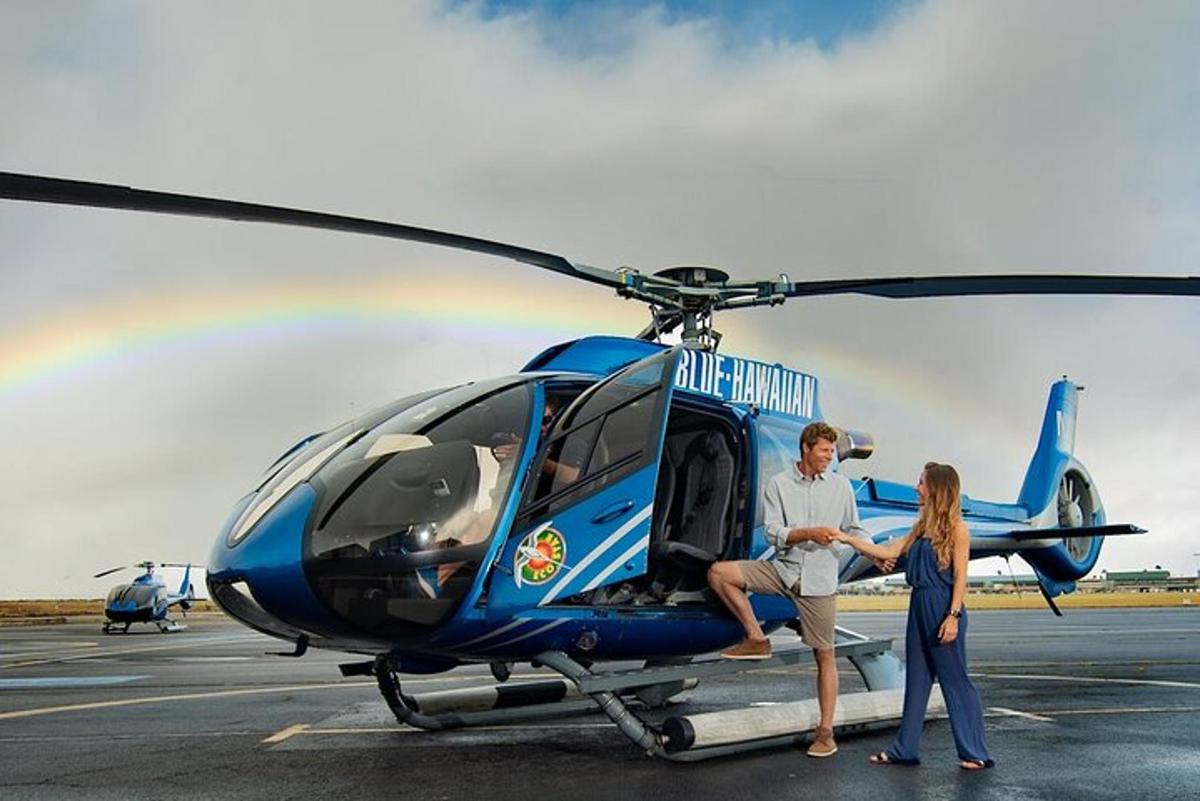 mężczyzna i kobieta stojący obok helikoptera