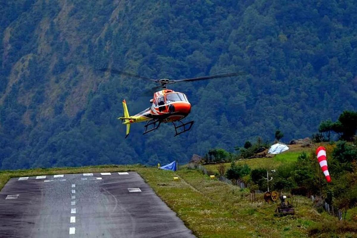 Ένα κόκκινο και κίτρινο ελικόπτερο που πετάει πάνω από έναν διάδρομο