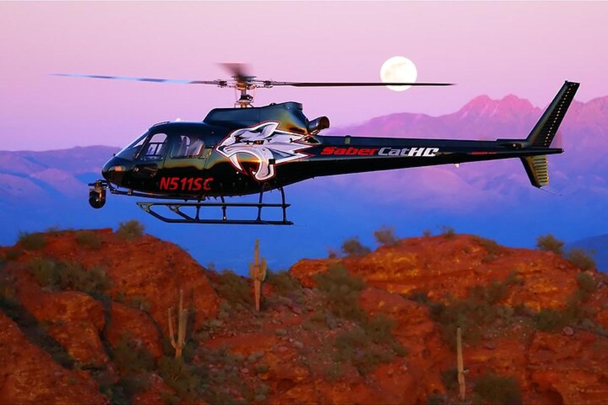 helikopter lecący nad górą z księżycem w tle