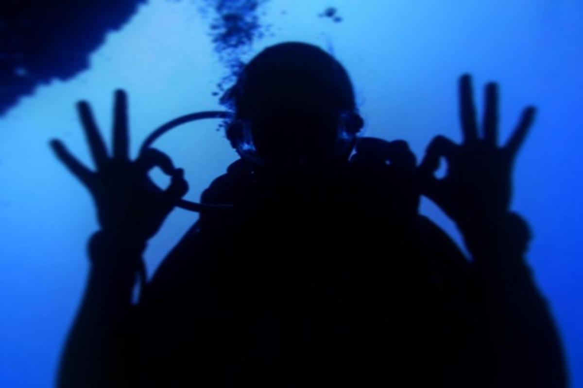 a person with their hands up in the dark