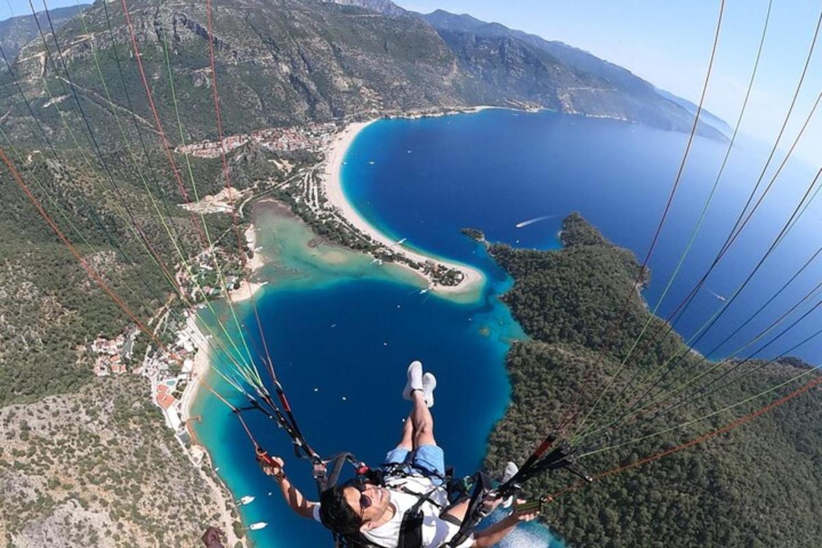 moški leti s padalom nad vodno površino
