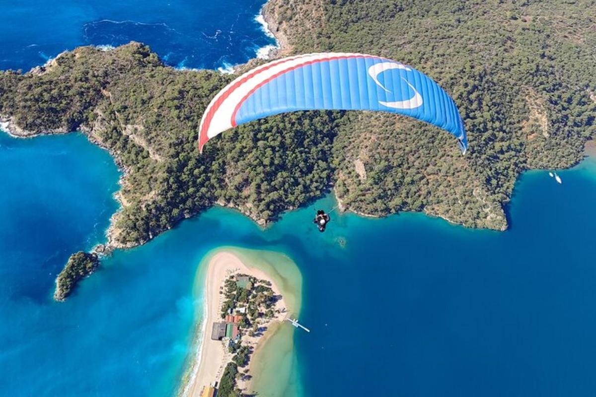 en paraglider som flyger över en liten ö i vattnet