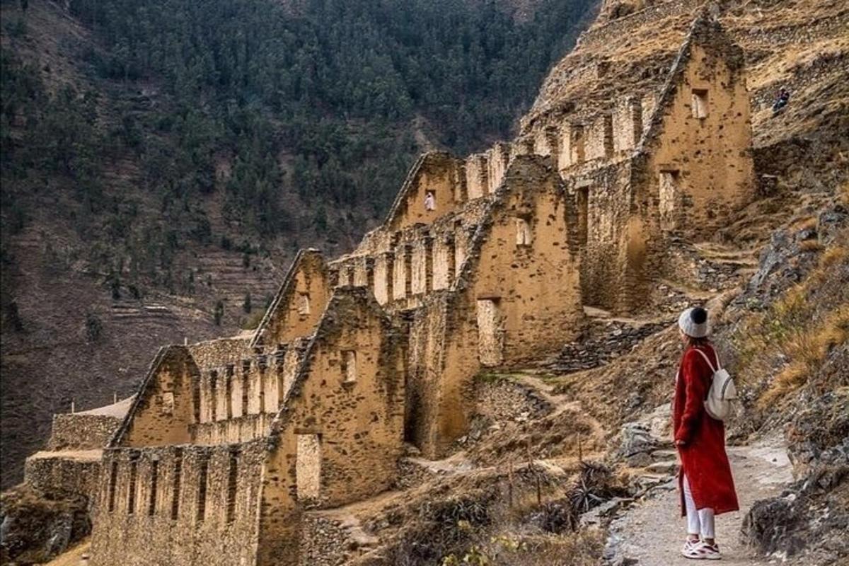 une personne debout sur une montagne regardant un bâtiment
