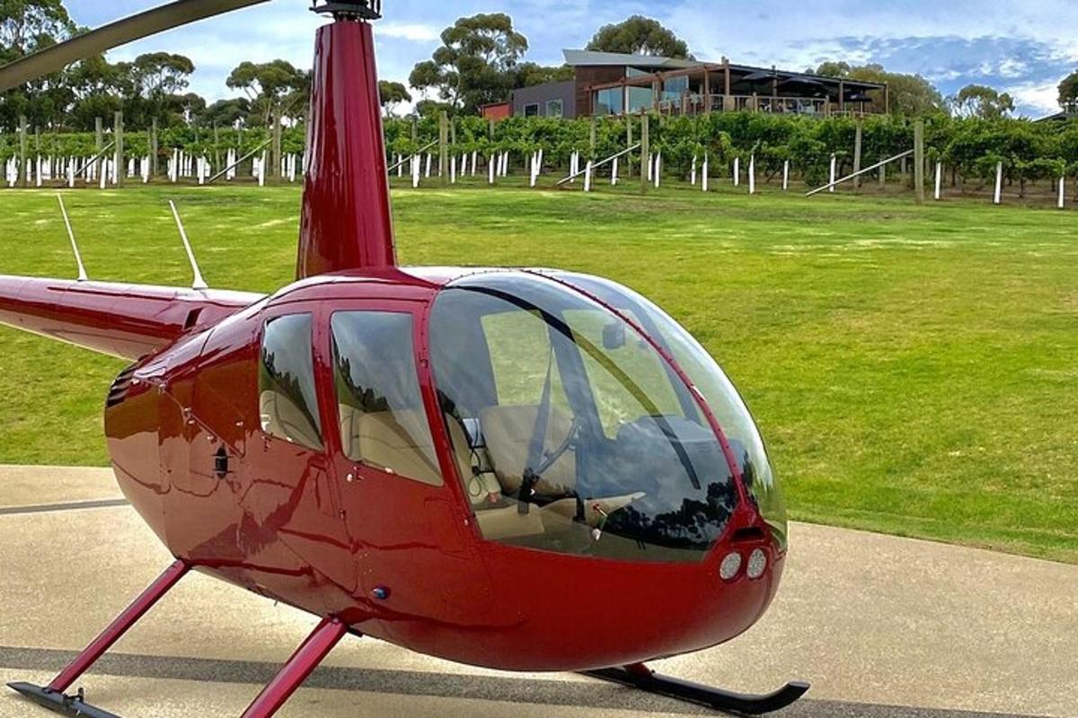 a red helicopter is sitting on a runway