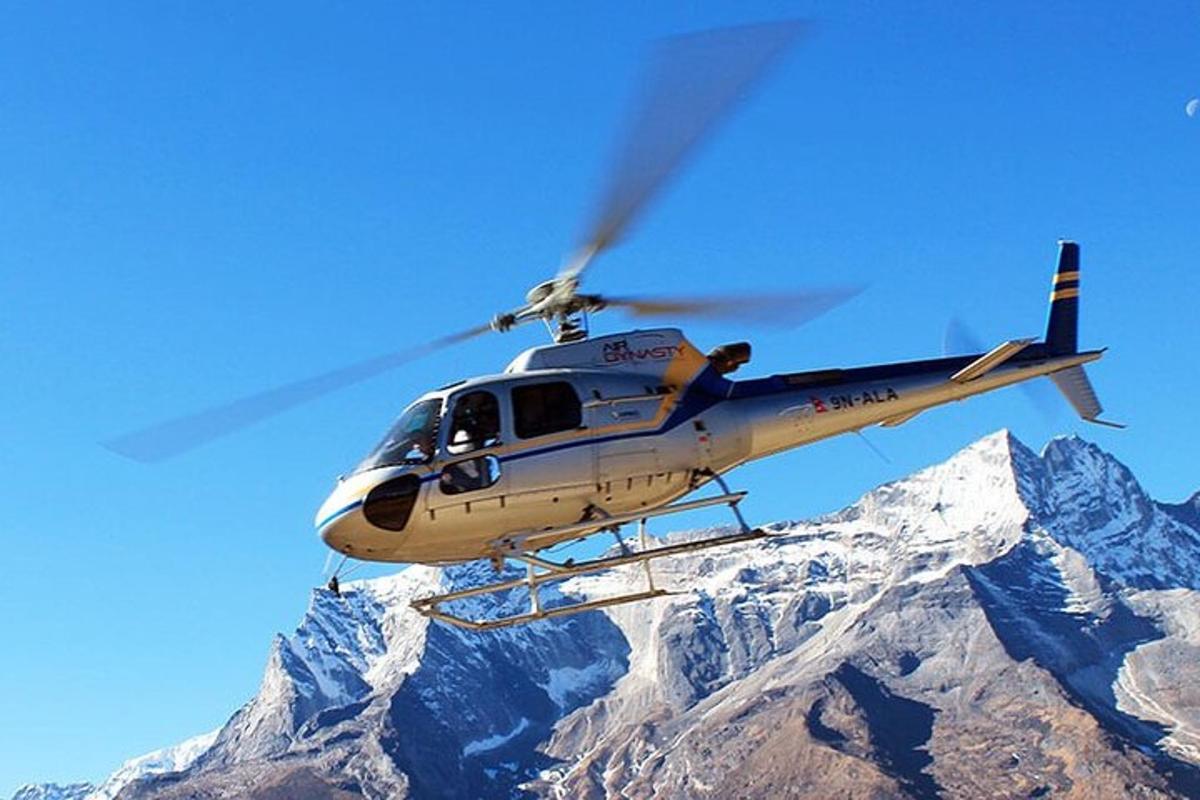 helikopter leti iznad planine prekrivene snijegom