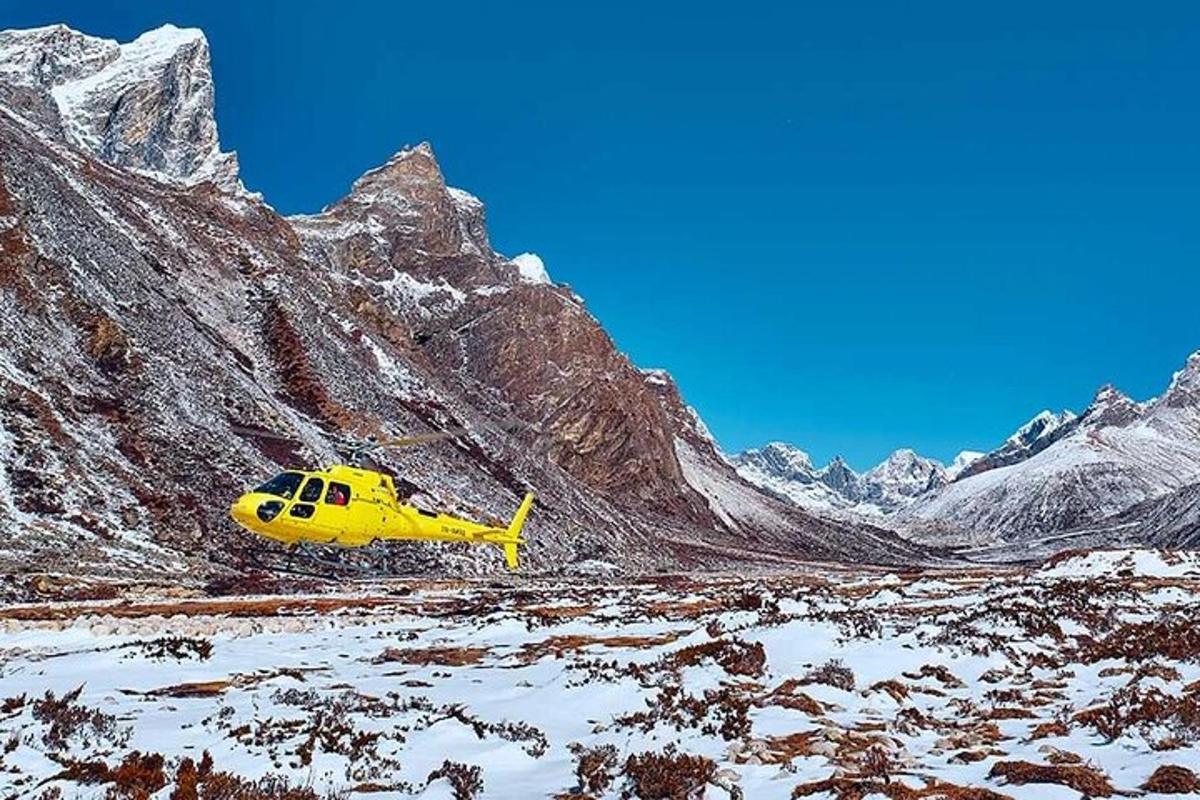 żółty helikopter zaparkowany na ośnieżonej górze