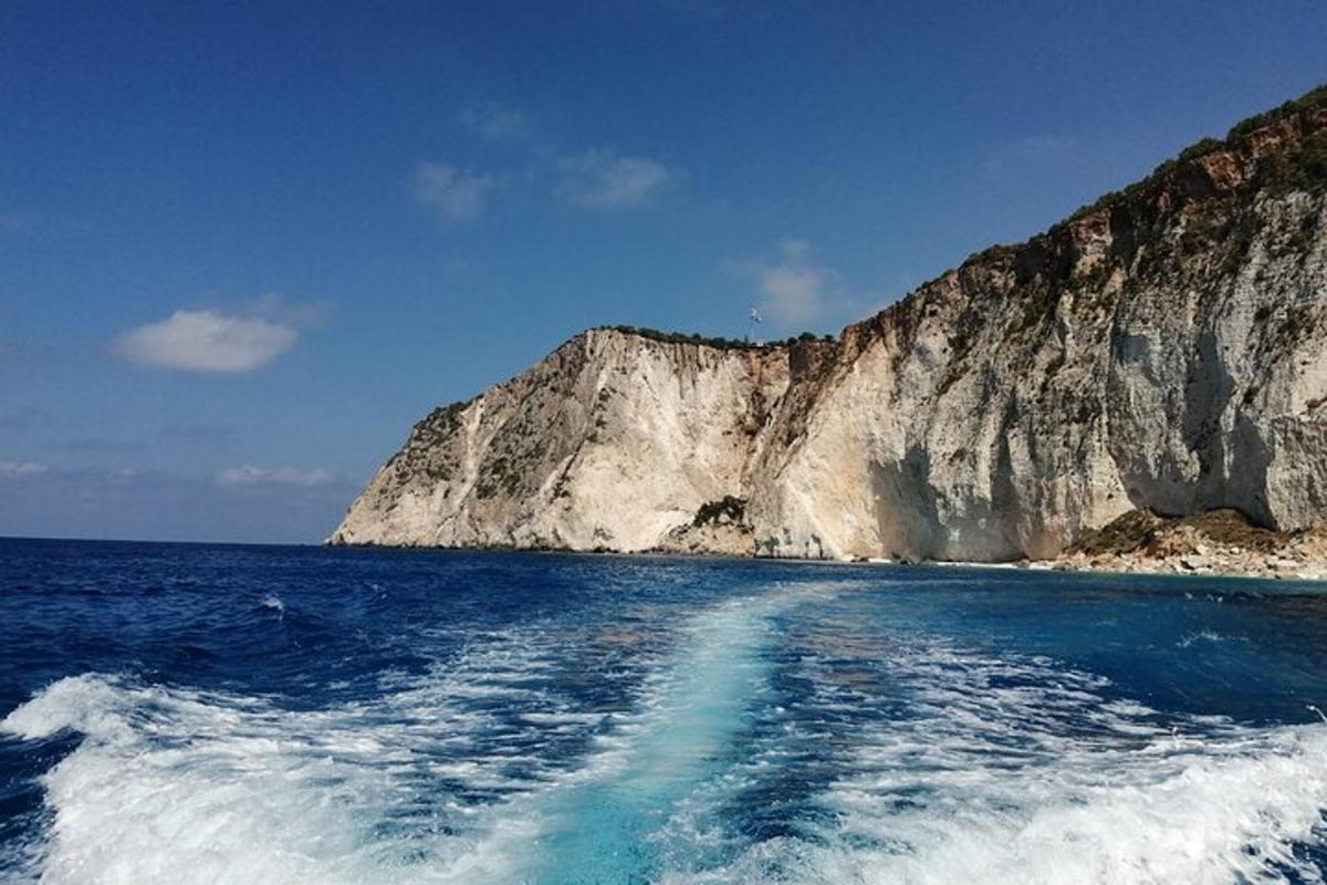 μια βάρκα στον ωκεανό κοντά σε ένα μεγάλο βουνό