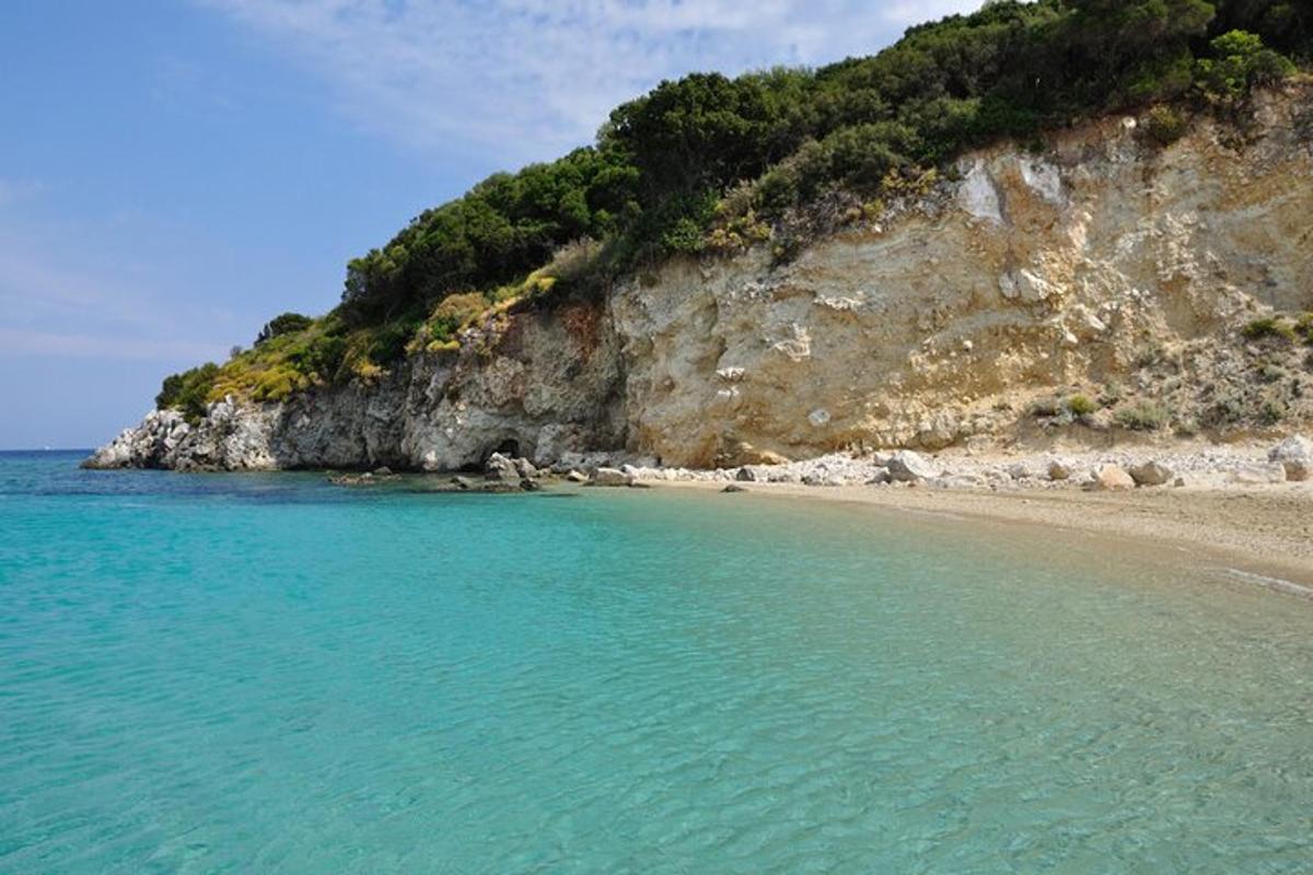μια παραλία με γαλάζια νερά δίπλα σε ένα βουνό