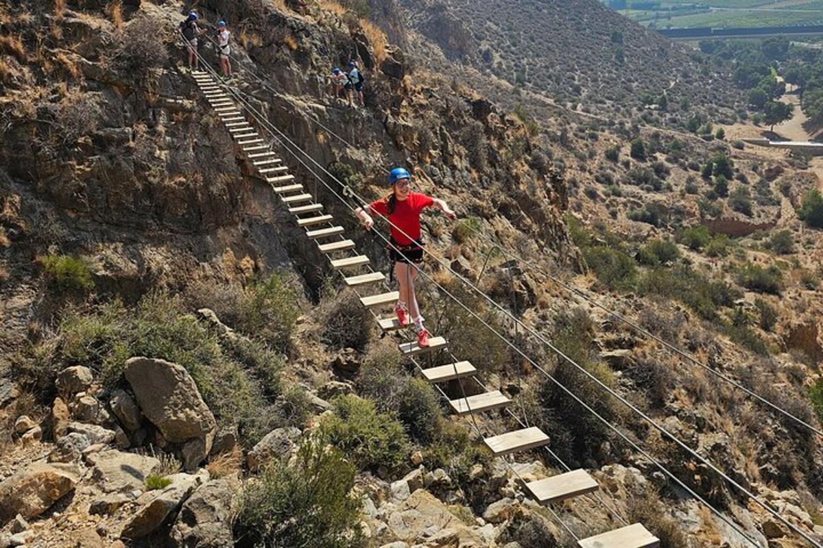 isang taong nakatayo sa isang suspension bridge sa isang bundok