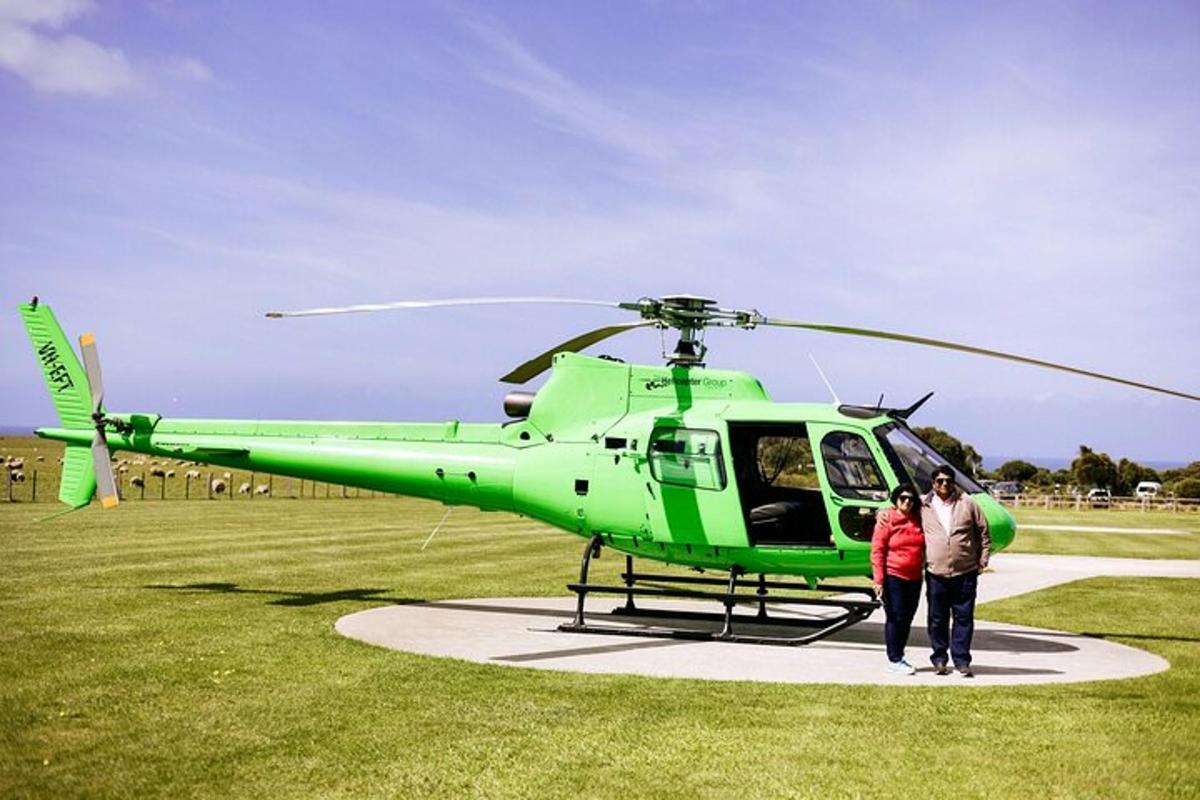 két ember áll egy zöld helikopter mellett