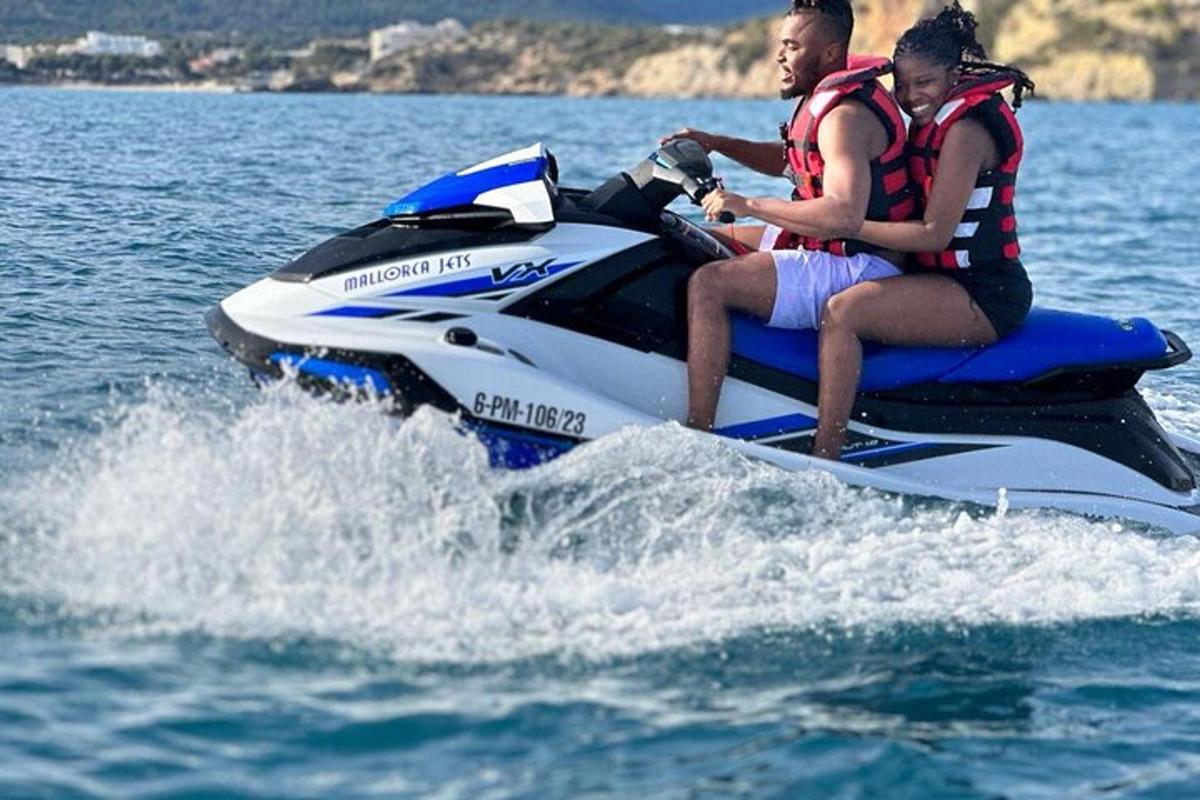 Suda jet ski üzerinde giden iki kişi